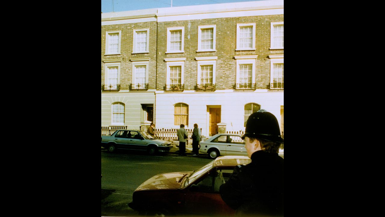 Reporters stand outside Rushdie's London home on February 16, 1989, as a police officer watches from across the street.