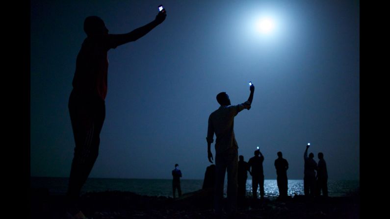 <strong>World Press Photo of the Year 2013: </strong>African migrants on the shore of Djibouti raise their phones in an attempt to capture an inexpensive signal from neighboring Somalia, a tenuous link to relatives abroad. Djibouti is a common stop-off point for migrants on their way from such countries as Somalia, Ethiopia and Eritrea, seeking a better life in Europe and the Middle East. The following are a selection of the other World Press Photo winners.