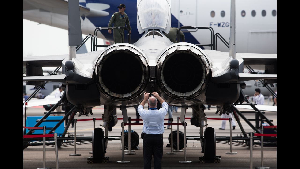 An attendee takes a photograph of the Boeing Co. F-15SG Strike Eagle fighter jet on February 11.