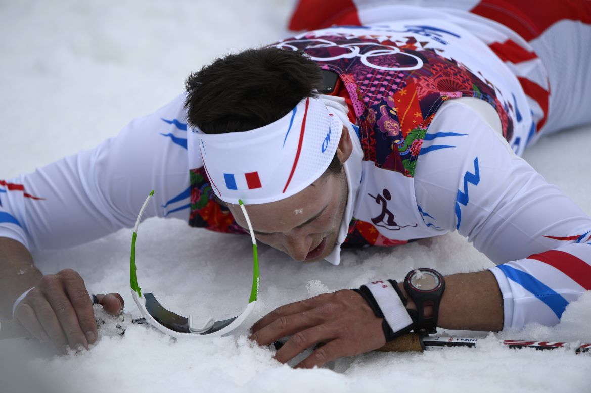 French skier Adrien Backscheider lies on the snow after the men's 15-kilometer classic.