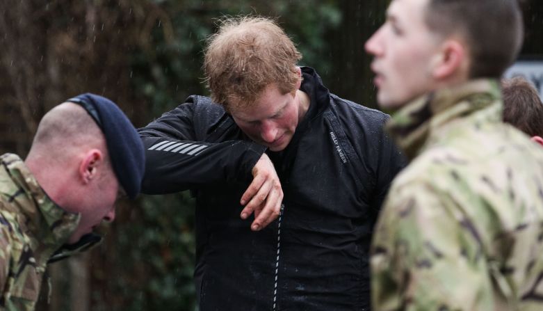 Prince Harry wipes his face February 14. The Environment Agency has warned of more flooding along the River Thames over the weekend as the river reaches its highest level in 60 years.