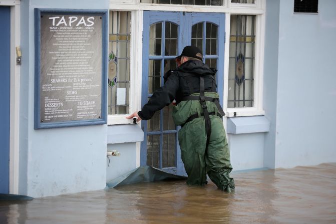 A police officer checks flooded properties in Worcester, England.