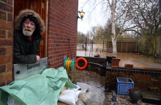 Richard Perry looks out the back door of his house in Gloucester, England, as the River Severn rises to record heights.