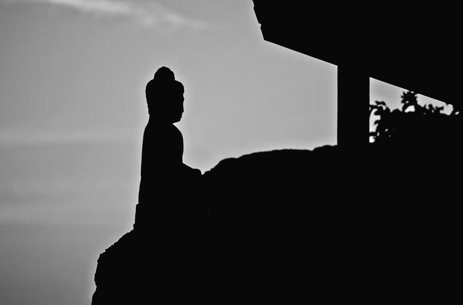 A statue balances on the edge of a cliff on Necker. In February 2014 the island hosted a summit of financiers, politicians, energy companies and lawyers in an attempt to encourage green energy practices in the Caribbean.
