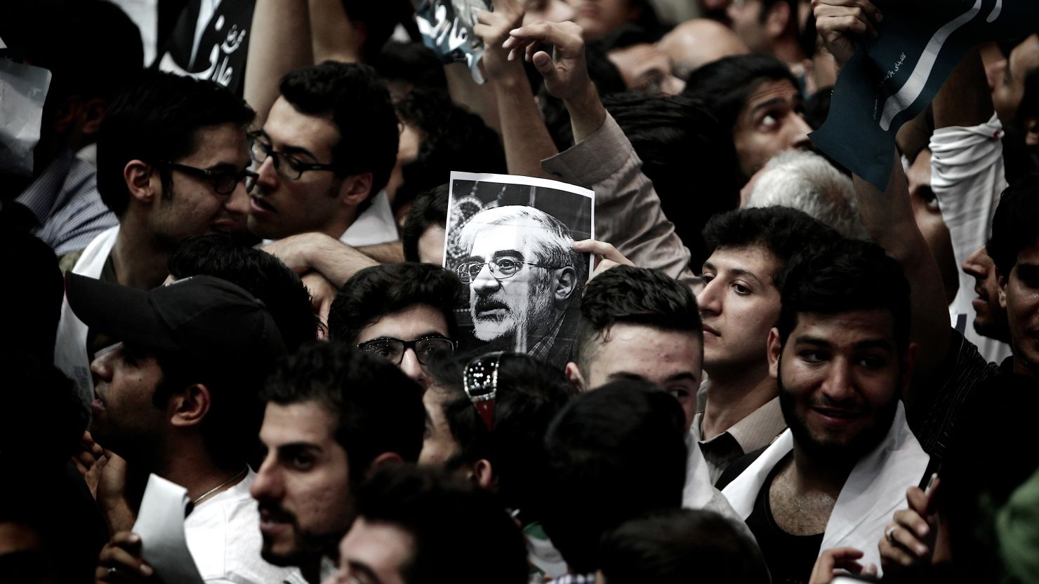 A portrait of opposition leader Mir Hossein Mousavi is held during a campaign rally in Tehran on June 10, 2013.