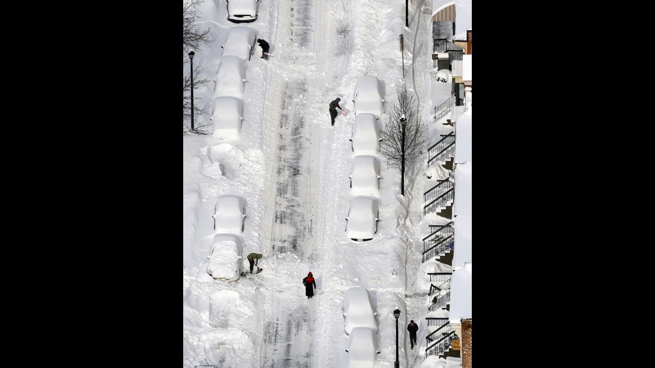 People dig out vehicles buried in snow in Albany, New York, on February 14.