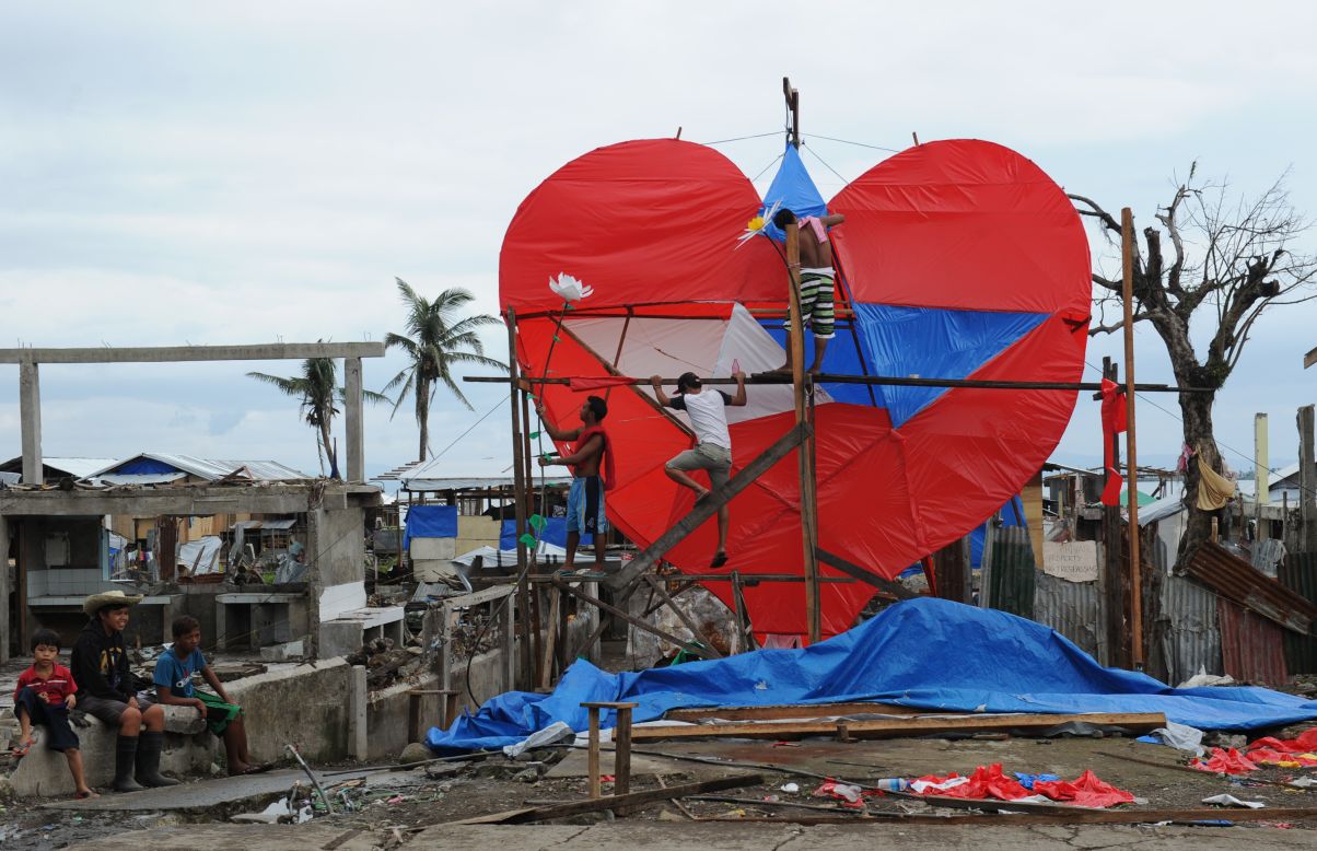 FEBRUARY 14 - TACLOBAN, PHILIPPINES: Residents and survivors of typhoon Haiyan put the finishing touches to a giant heart-shaped lantern displayed along the coastal area of Tacloban City, in central Philippines. Tacloban was among the worst hit places by the typhoon, which killed over 6,200 people.