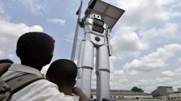 This picture taken on January 22, 2014 shows a traffic robot cop on Triomphal boulevard of Kinshasa at the crossing of Asosa, Huileries and Patrice Lubumba streets. Two human-like robots were recently installed here to help tackle the hectic traffic usually experienced in the area. The prototypes are equipped with four cameras that allow them to record traffic flow, the information is then transmitted to a center where traffic infractions can be analyzed. The team behind the new robots are a group of Congolese engineers based at the Kinshasa Higher Institute of Applied Technique, known by its French acronym, ISTA.