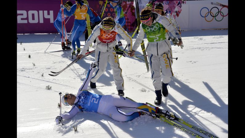 Sweden's Ida Ingemarsdotter, Emma Wiken and Anna Haag jump on teammate Charlotte Kalla after winning gold February 15 in the women's cross-country relay.