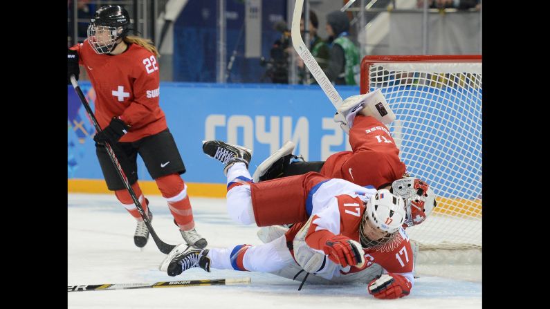 Russian forward Yekaterina Smolentseva tumbles over Swiss goalie Florence Schelling during the women's hockey game on February 15.