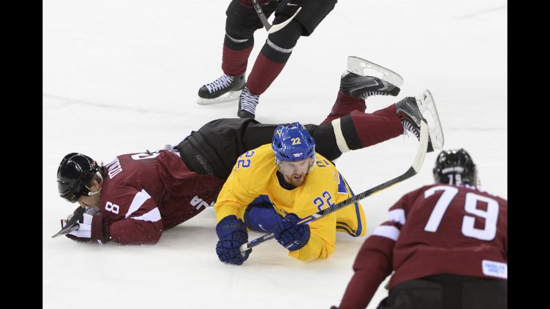 Swedish hockey player Daniel Sedin, in yellow, vies with Latvia's Sandis Ozolinsh on February 15.