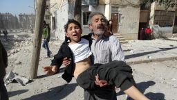 A Syrian man carries a wounded child following a reported air strike attack by government forces on the outskirts of the northern Syrian city of Aleppo on February 14, 2014. More than 136,000 people have been killed in Syria's brutal war since March 2011, and millions more have fled their homes