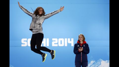 U.S. silver medalist Noelle Pikus-Pace jumps in the air as Great Britain's gold medalist Elizabeth Yarnold looks on during the women's skeleton medal ceremony on Saturday, February 15.