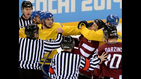 Tempers flare late in the third period as Swedish hockey forward Jimmie Ericsson, left, grabs the face of Latvian defenseman Sandis Ozolinsh on February 15.