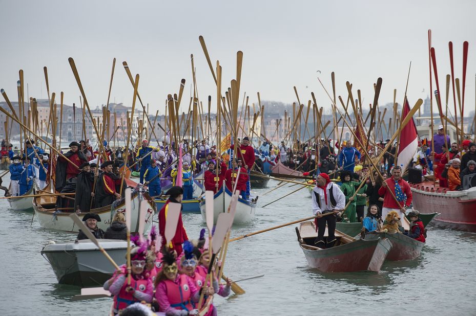 Rowers lift their oars in a sign of salute ahead of the traditional regatta on the Grand Canal, which officially opens the Venice Carnival, on Sunday, February 16, in Italy.