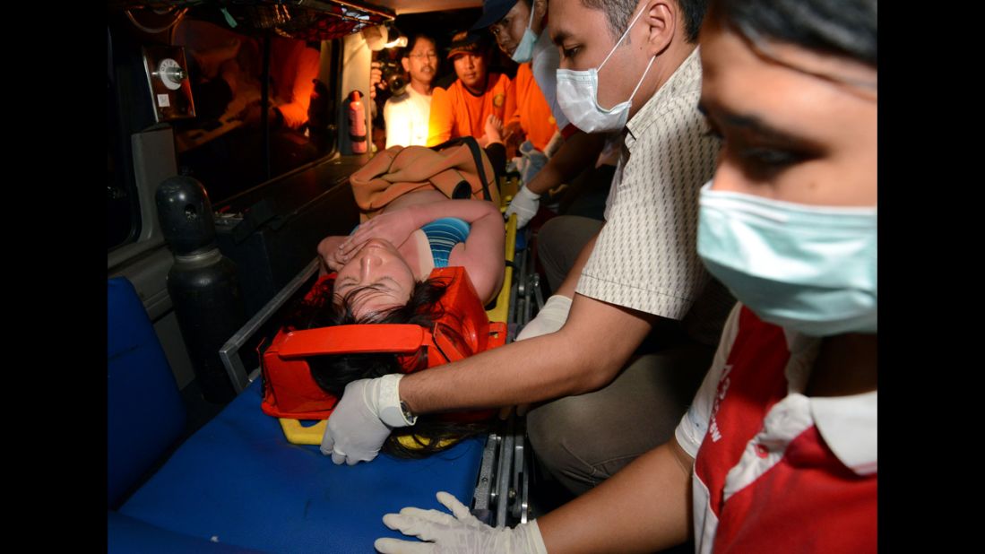 One of the Japanese divers is carried onto an ambulance.