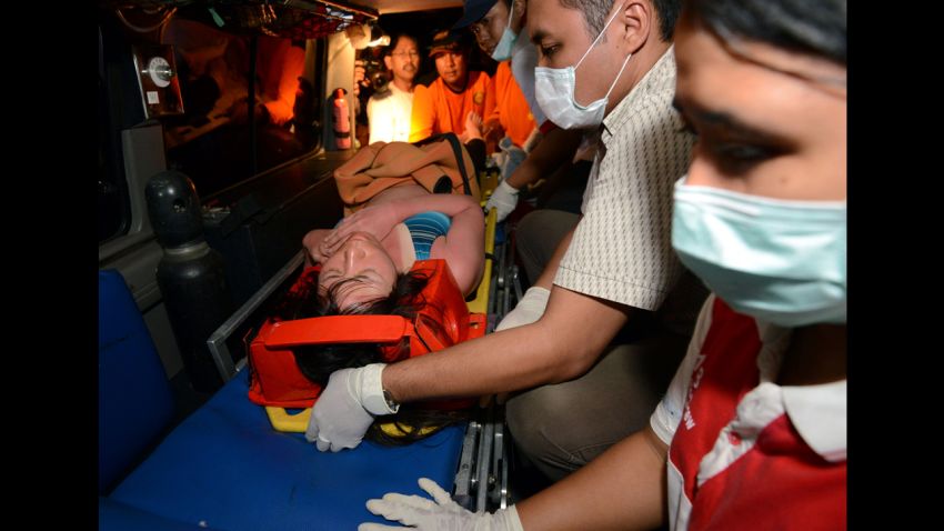 A Japanese scuba diver is carried onto an ambulance from a boat as she arrives in Sanur in Denpasar on the Indonesian island of Bali after being rescued on February 17, 2014. Five Japanese scuba divers were found alive on February 17 clinging to a coral reef in rough waters off the Indonesian resort island of Bali three days after they went missing, officials said.  AFP PHOTO/SONNY TUMBELAKA        (Photo credit should read SONNY TUMBELAKA/AFP/Getty Images)