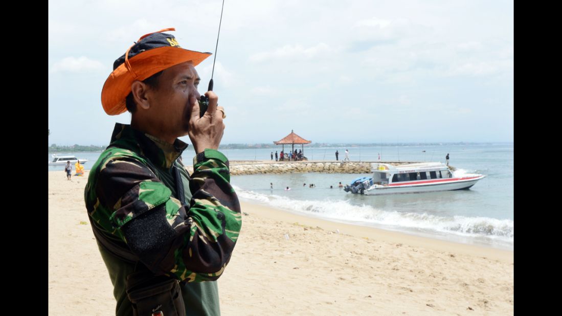 An Indonesian rescue officer monitors a search team at a Bali beach on Sunday.