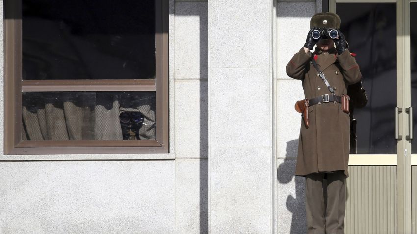 A North Korean soldier looks at southern side through a pair of binoculars at the border village of Panmunjom, which has separated the two Koreas since the Korean War, South Korea, Thursday, Feb. 6, 2014. North Korea threatened Thursday to cancel a reunion later this month of Korean War-divided families because of upcoming U.S.-South Korean military drills, causing frustration in Seoul only one day after the rivals agreed on dates for the emotional meetings. (AP Photo/Yonhap, Shin Jun-hee)  KOREA OUT