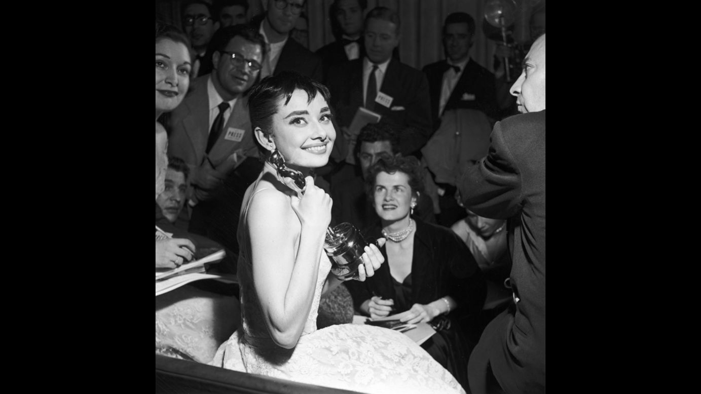 <strong>Audrey Hepburn (1954):</strong> Audrey Hepburn is surrounded by reporters as she holds her best actress Oscar for "Roman Holiday."