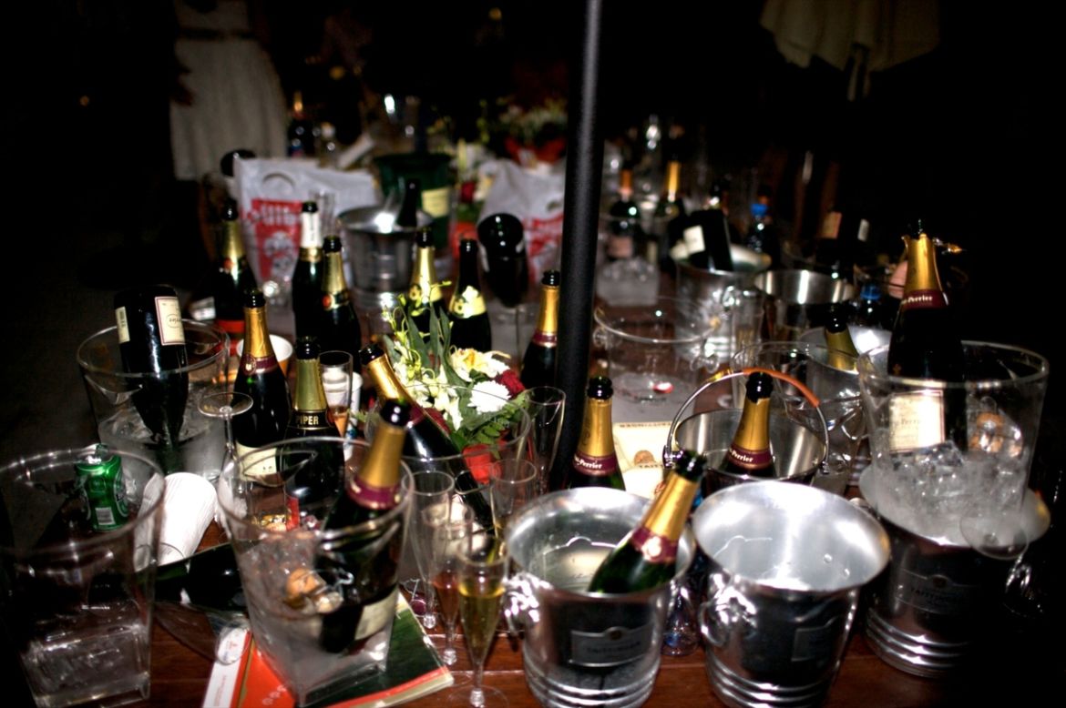 Champagne bottles, ice buckets and a rogue can of lager lie strewn across a table in the Bubble Lounge.  