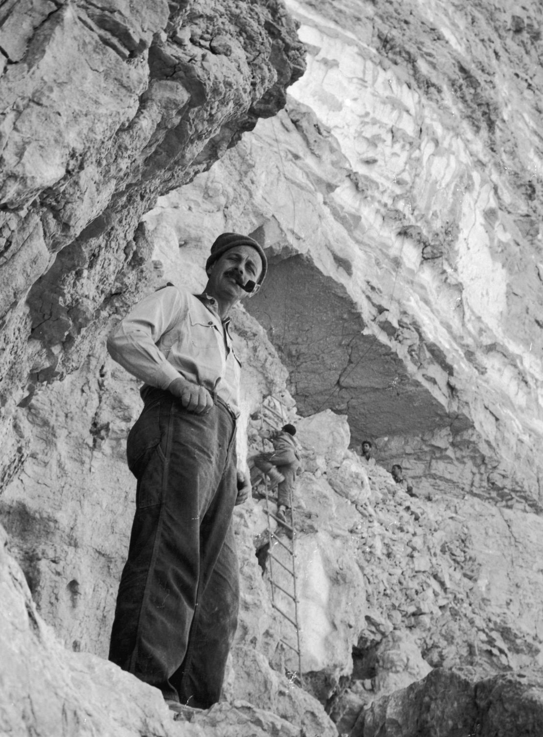 Israeli archaeologist and military leader Yigael Yadin smokes a pipe in front of the 'Cave of Letters,' where the Dead Sea Scrolls were discovered in 1947, Qumran, Israel.