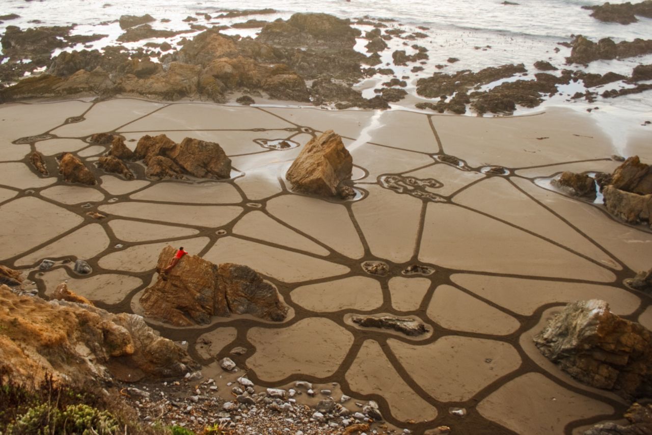 Amador ha creado cientos de murales de playa, a veces integrando aspectos del paisaje natural en su obra. 