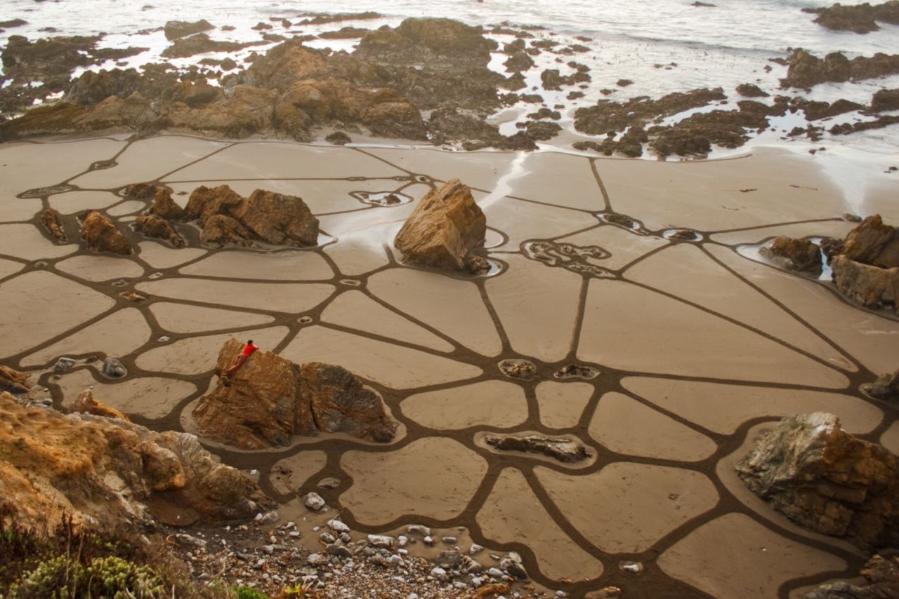 Amador ha creado cientos de murales de playa, a veces integrando aspectos del paisaje natural en su obra.