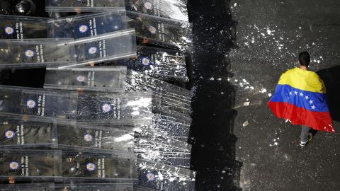 A protester walks past a line of riot police in Caracas on February 12.
