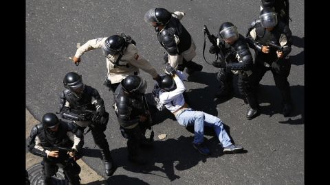 A demonstrator is detained after jumping over a riot police line in Caracas on February 12.