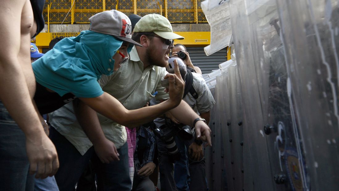 Protesters confront riot police in Caracas on February 12.