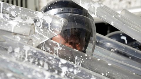 Riot police protect themselves during an opposition rally in Caracas on February 12.