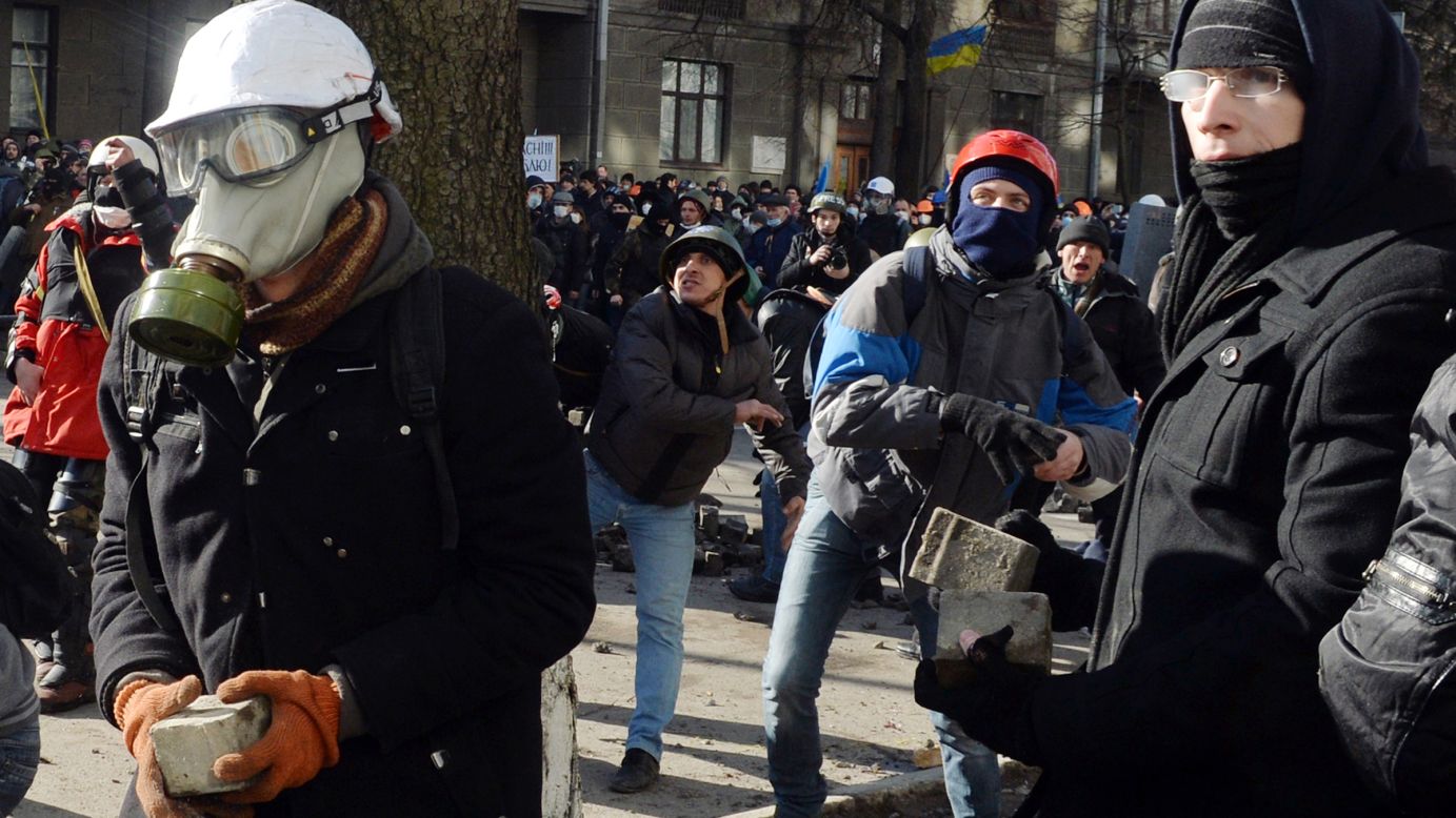 Protesters throw stones toward riot police in Kiev on February 18.