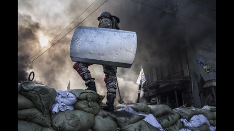 A protester stands atop a barricade in Kiev on February 18.