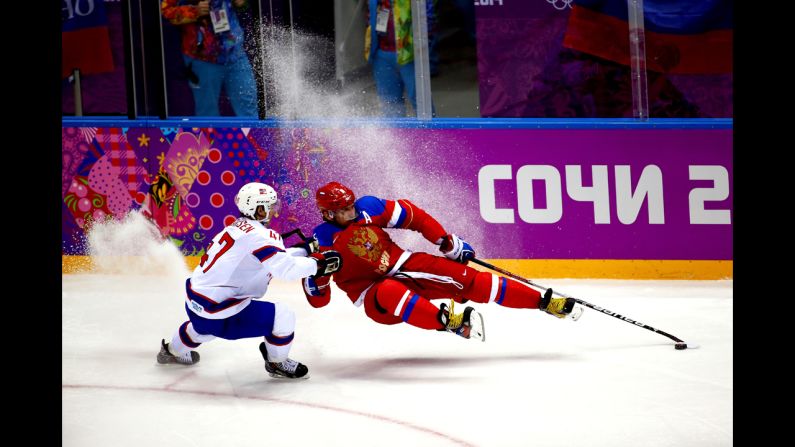Russian hockey player Alexander Ovechkin, right, falls while playing against Norway's Alexander Bonsaksen during an Olympic game Tuesday, February 18.