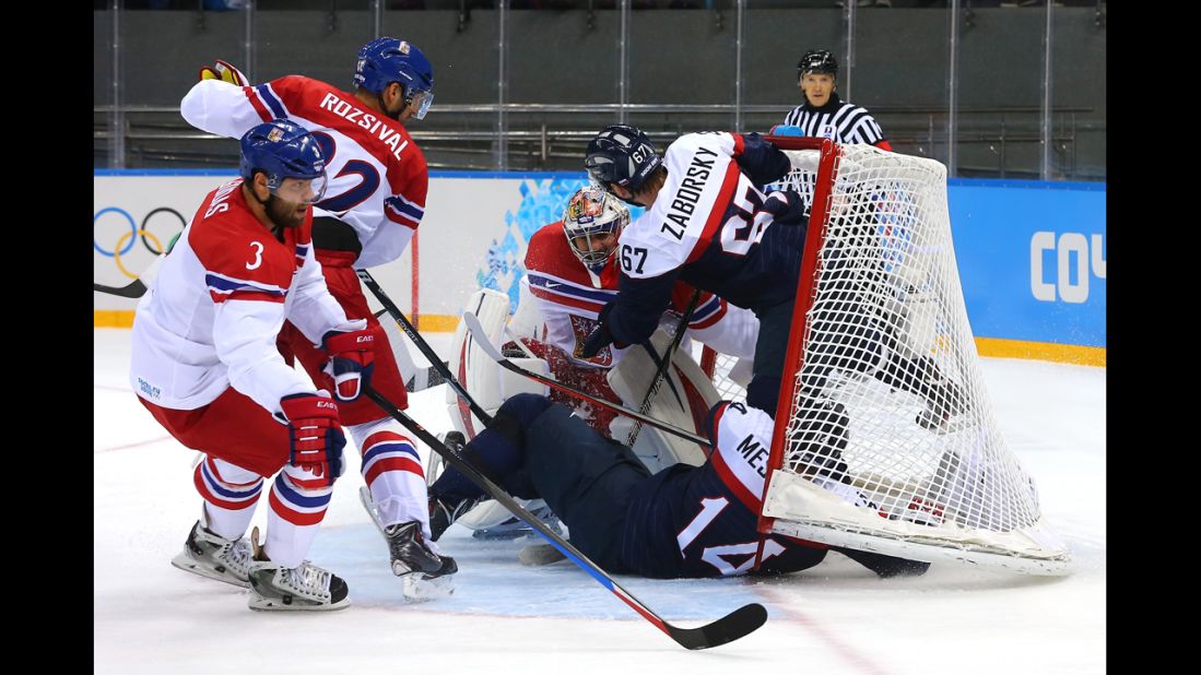 Slovakian hockey players Andrej Meszaros and Tomas Zaborksy crash into Czech goalie Ondrej Pavelec on February 18.