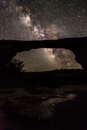 <strong>Natural Bridges National Monument (Utah): </strong>The natural Owachomo Bridge in Utah is silhouetted against the Milky Way and thousands of stars. This photo was taken on a particularly clear night after a storm, and features potholes full of water reflecting the scene, says photographer <a href="index.php?page=&url=http%3A%2F%2Fjwfrank.com" target="_blank" target="_blank">Jacob Frank</a>. 