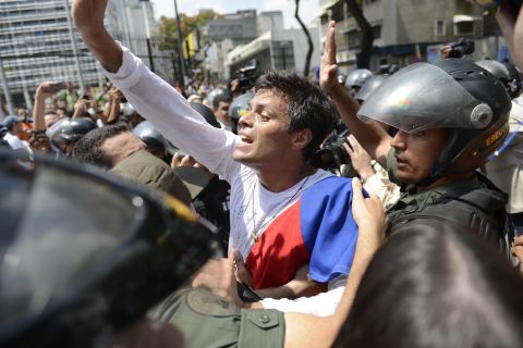 Leopoldo Lopez is escorted by members of the Venezuelan National Guard on Tuesday, February 18, after turning himself in to authorities.