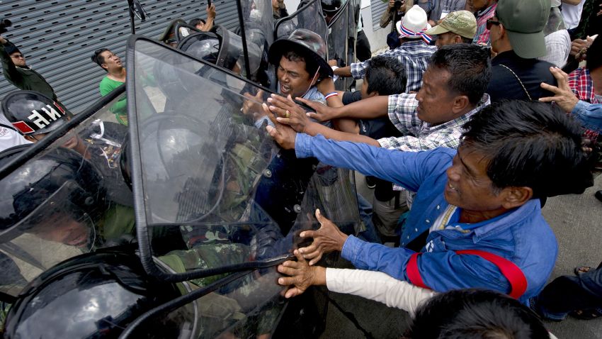 Thai farmers battle with soldiers as they protest the government's repeatedly delayed payments for rice submitted to the pledging scheme at the government's temporary office in Bangkok on February 17, 2014. Thai opposition demonstrators besieged government offices on February 17, including a compound that has been used as a temporary headquarters by Prime Minister Yingluck Shinawatra, in defiance of authorities who have vowed to reclaim key state buildings. AFP PHOTO / PORNCHAI KITTIWONGSAKUL (Photo credit should read PORNCHAI KITTIWONGSAKUL/AFP/Getty Images)