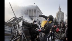 An anti-government protester throws a stone during clashes with riot police in Kiev's Independence Square, the epicenter of the country's current unrest, Kiev, Ukraine, Wednesday, Feb. 19, 2014. The deadly clashes in Ukraine's capital have drawn sharp reactions from Washington, generated talk of possible European Union sanctions and led to a Kremlin statement blaming Europe and the West.  (AP Photo/Efrem Lukatsky)