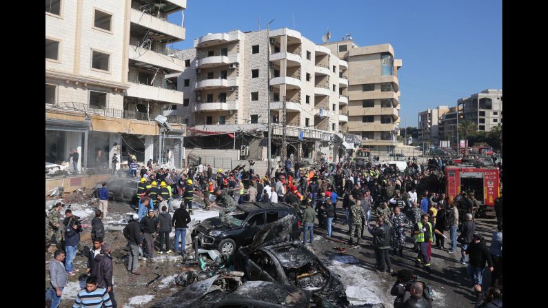 Emergency personnel and civilians inspect the site of one of the explosions. The al Qaeda-linked militant group Abdullah Azzam Brigades claimed responsibility for the attacks.