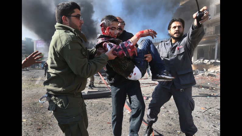 Men carry one of the injured after the blast in Beirut on February 19. The group with al Qaeda ties has warned of more attacks unless Iranian-backed Shiite militia Hezbollah stops sending fighters to support Syrian government forces.