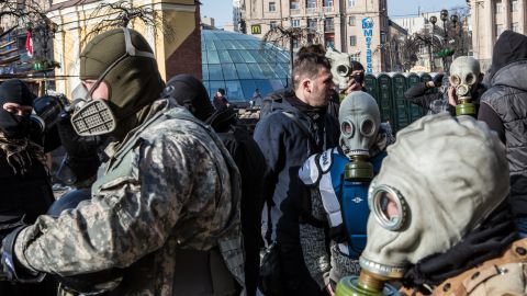 Protesters put on gas masks near the perimeter of Independence Square on February 19.