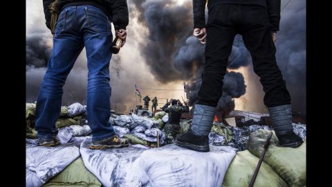 Protesters watch clashes in Kiev on February 18.