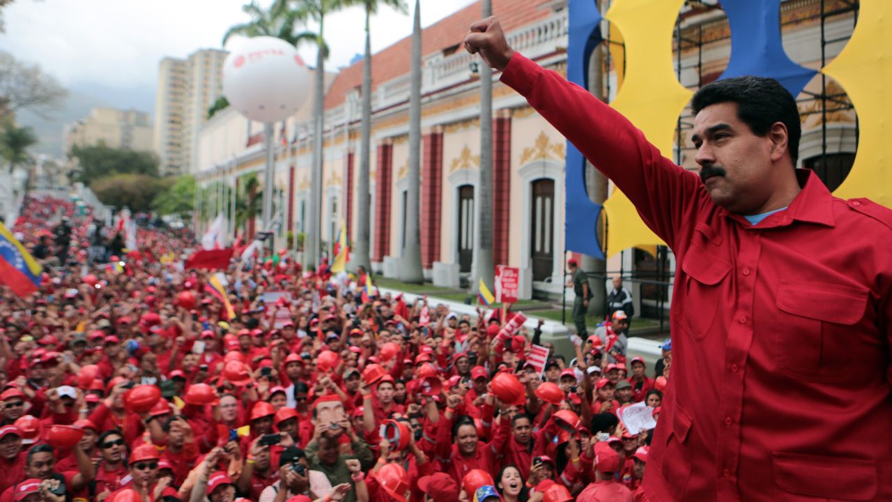 President Maduro raises his fist during a rally in Caracas on February 18, in this photo released by the Venezuelan government. Maduro and his supporters have blamed the opposition for causing the very problems it protests.