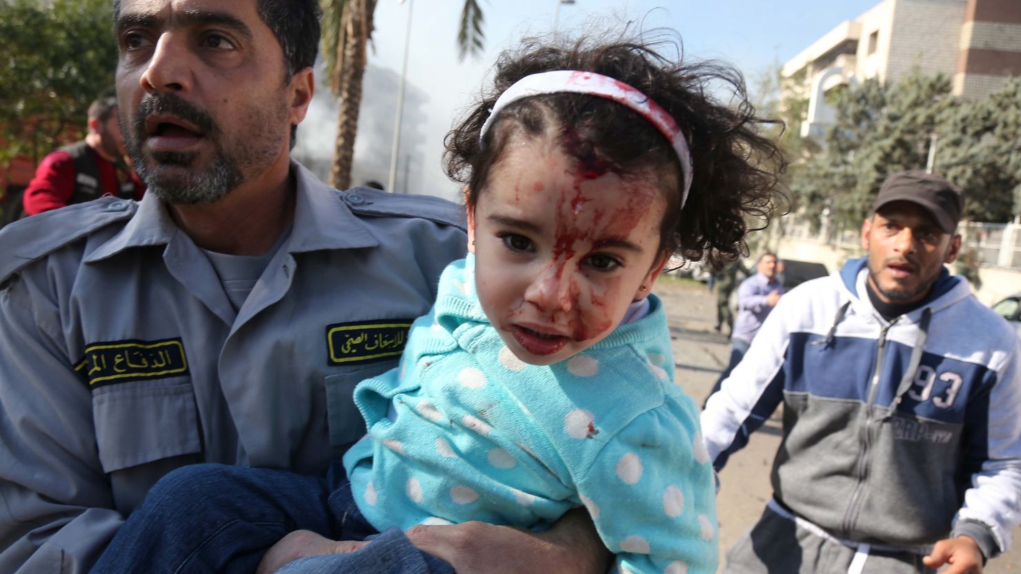 Lebanese emergency personnel evacuate an injured girl from an orphanage in Beirut on February 19, 2014.