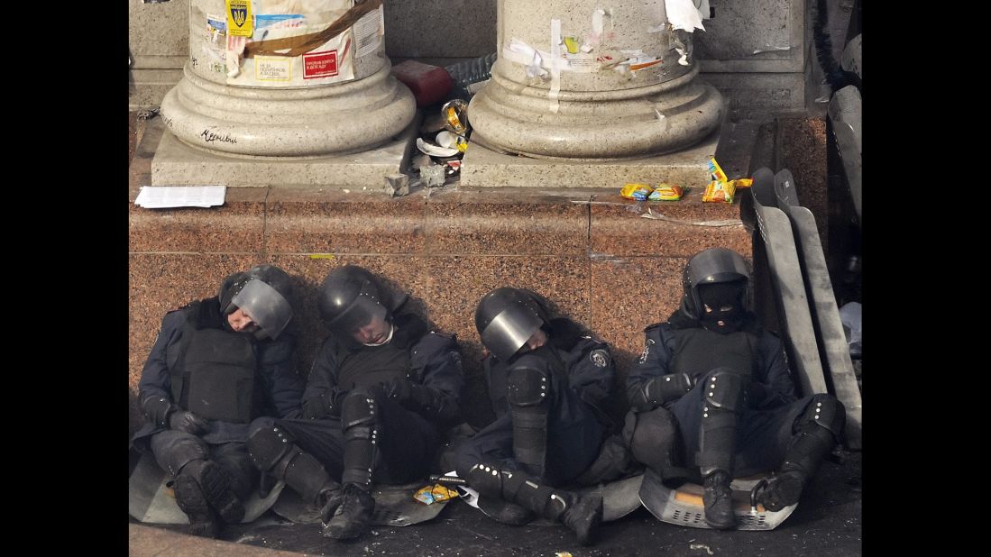 Riot police officers rest against a column in Independence Square on February 19.