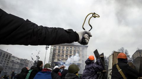 A protester uses a slingshot to throw a rock at riot police February 19 in Kiev.