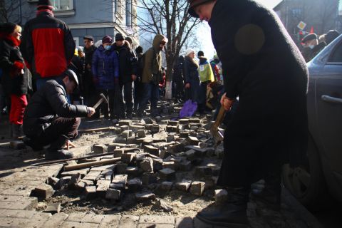 A woman on a Kiev street digs up pavement bricks to be used as weapons by pro-Europe demonstrators. Ukrainian student <a href="http://ireport.cnn.com/docs/DOC-1087308">Oleksandr Guzenko</a> said he was fascinated by "how motivated and brave [protesters] were to stand there and make a change, support and contribute."
