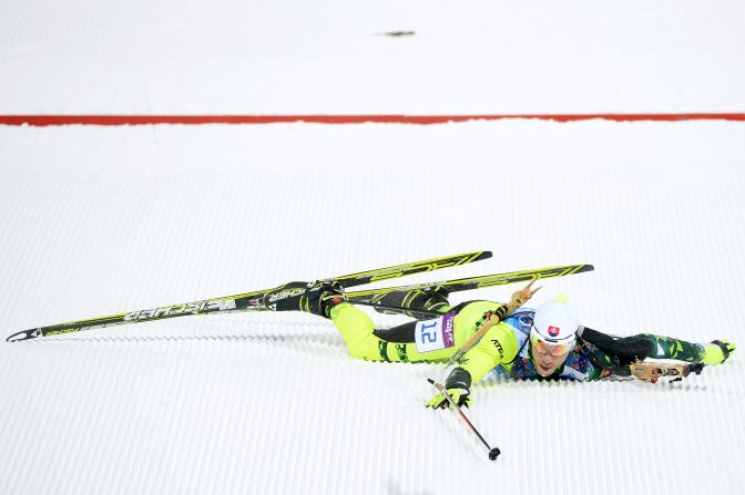 Biathlete Matej Kazar of Slovakia falls over the finish line during the mixed relay event on February 19.